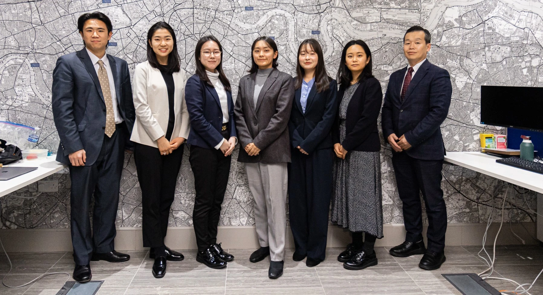 Group photo of the Benham & Reeves Japan team standing in their Tokyo office
